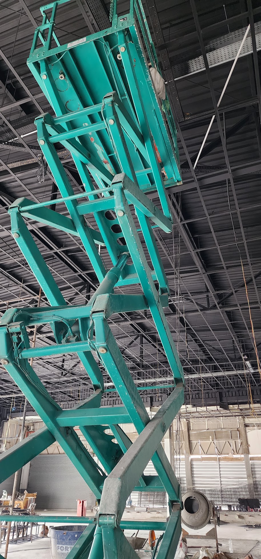 Plataforma elevatória em galpão durante trabalho na estrutura do teto